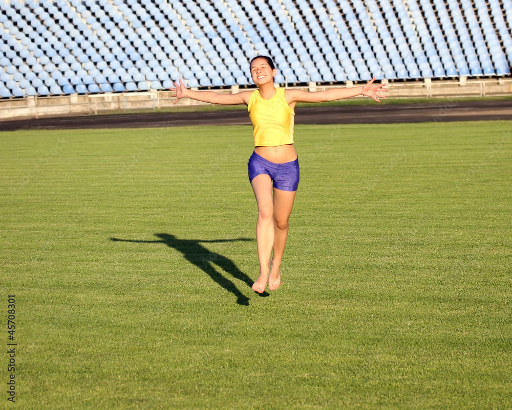 Beautiful teenage sport girl running on the stadium