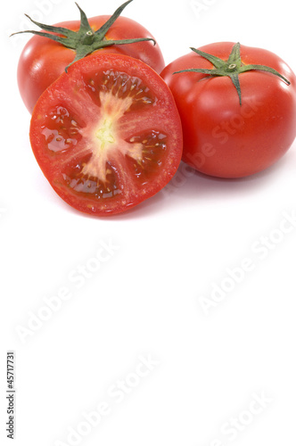 Red tomatoes and half on a white
