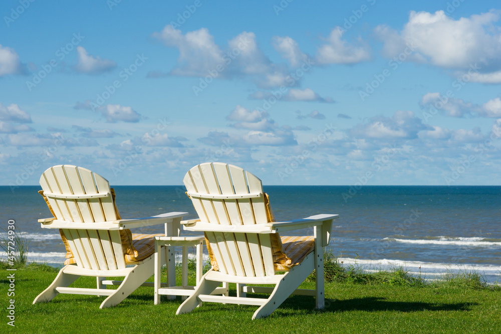 two beach chairs  on an empty meadow