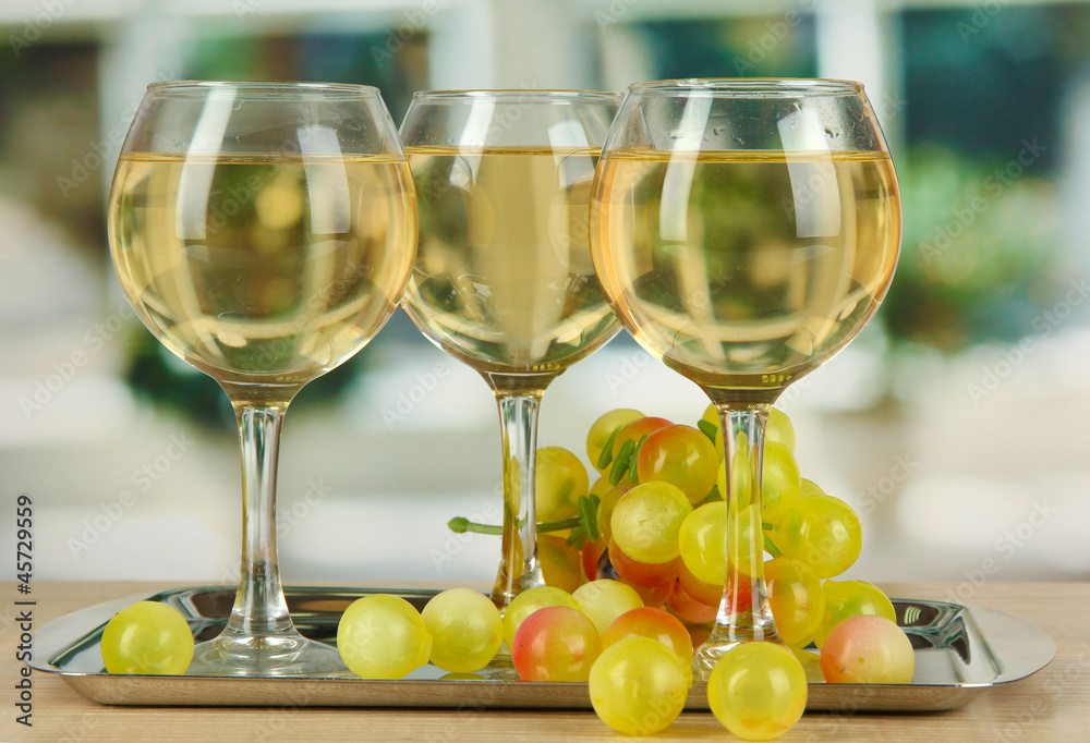 White wine in glass on salver on window background White wine in glass on salver on window background