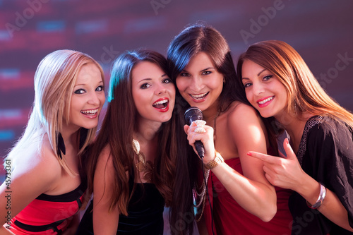 Four beautiful girls singing karaoke