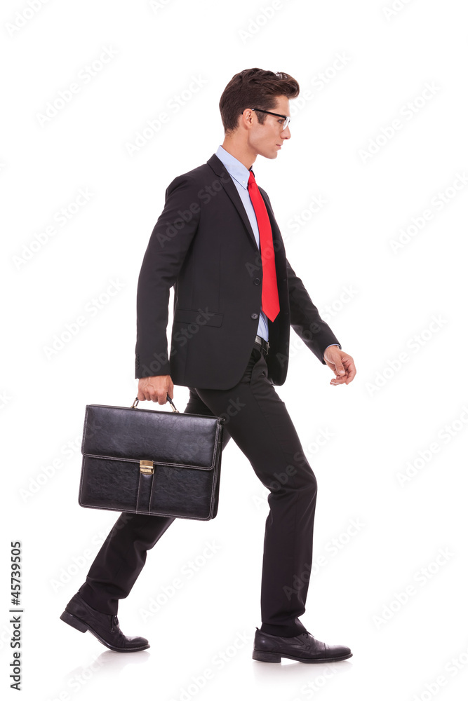 serious business man holding a briefcase and walking serious business man holding a briefcase and walking