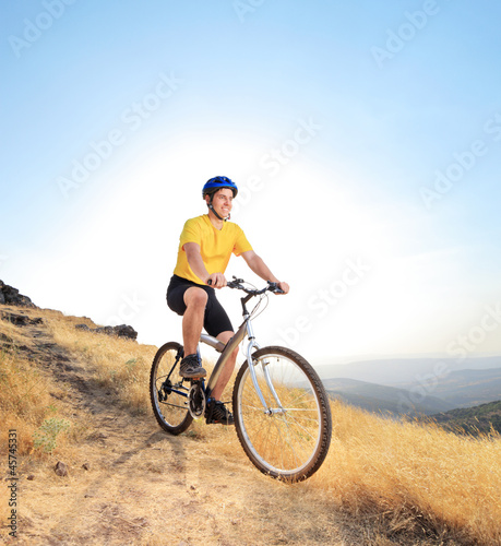 A biker riding a mountain bike on a dirty road