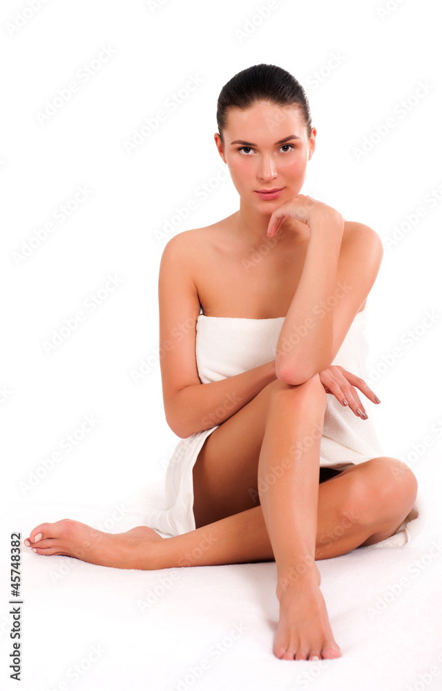 Obraz premium Beautiful young woman sitting in white towel