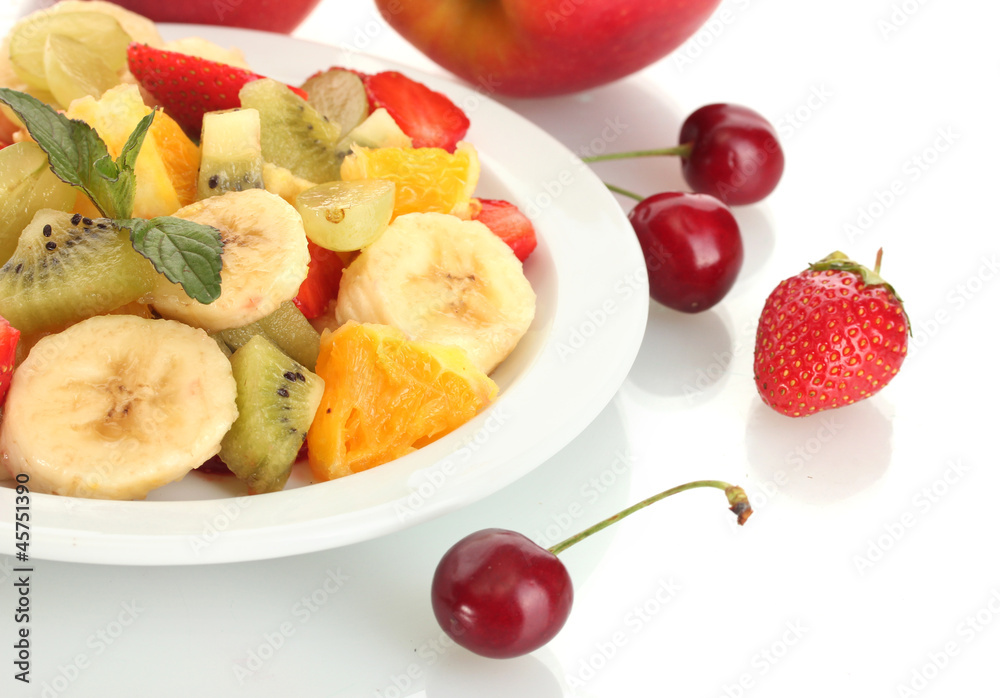 Fresh fruits salad on plate and berries isolated on white Fresh fruits salad on plate and berries isolated on white