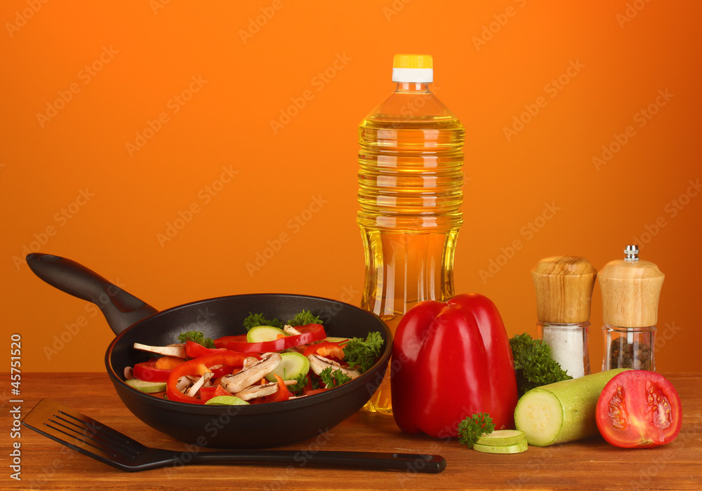 frying pan with vegetables on red background frying pan with vegetables on red background