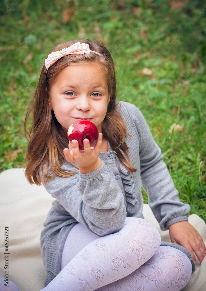 little girl is eating apple outdoor little girl is eating apple outdoor