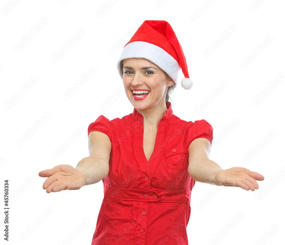Smiling woman in Santa hat showing something on empty palms Smiling woman in Santa hat showing something on empty palms