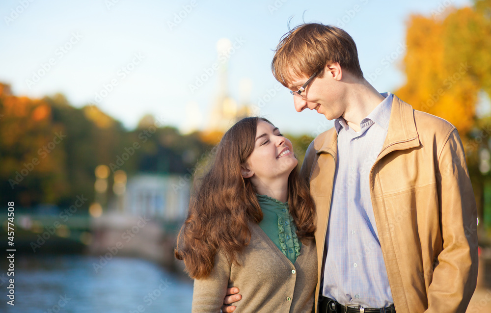 Fototapeta premium Young positive couple enjoying warm autumn day outdoors
