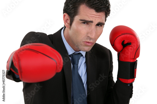 Vászonkép young businessman with boxing gloves