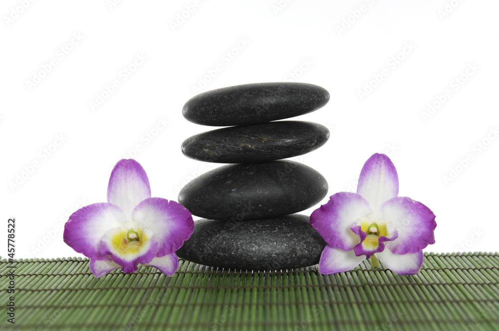 Stone tower with two pink orchid on green mat