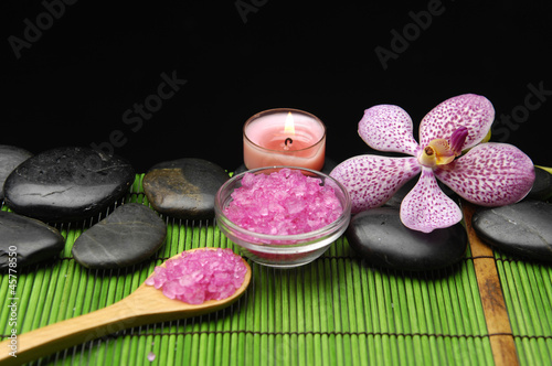 candle with zen stone and sea salt in spoon on green mat