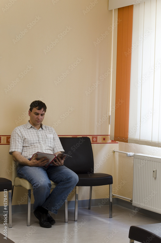 Mann sitzt im Wartezimmer einer Arztpraxis