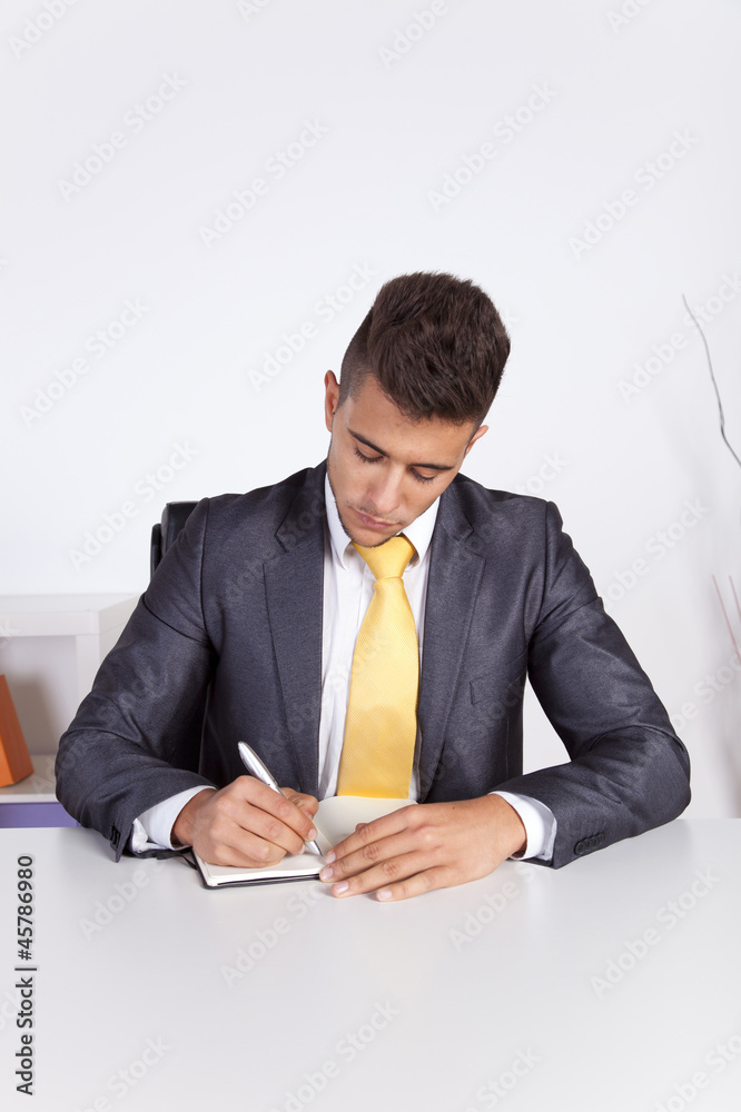 Businessman writing on the notepad Businessman writing on the notepad