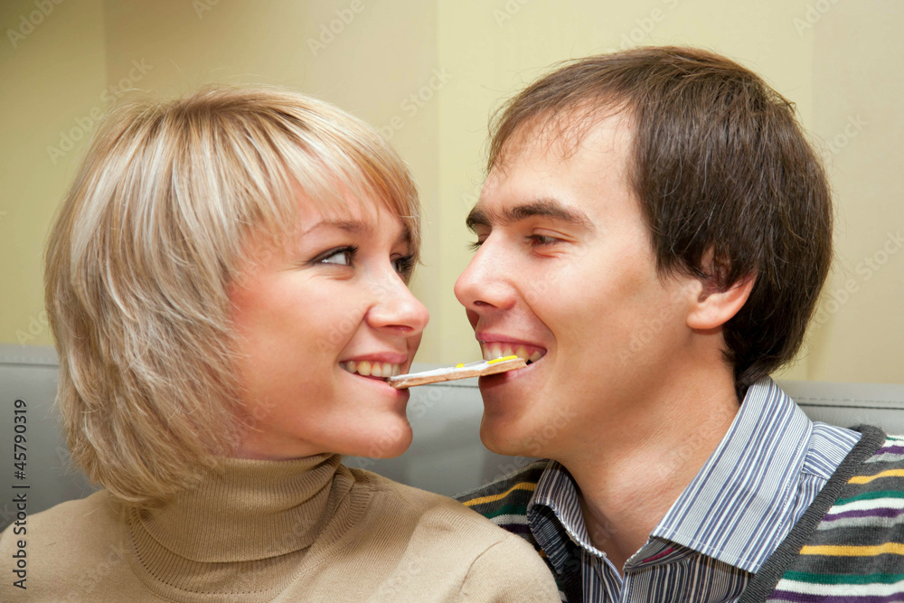 couple eating one cookie for two, looking eye to eye couple eating one cookie for two, looking eye to eye