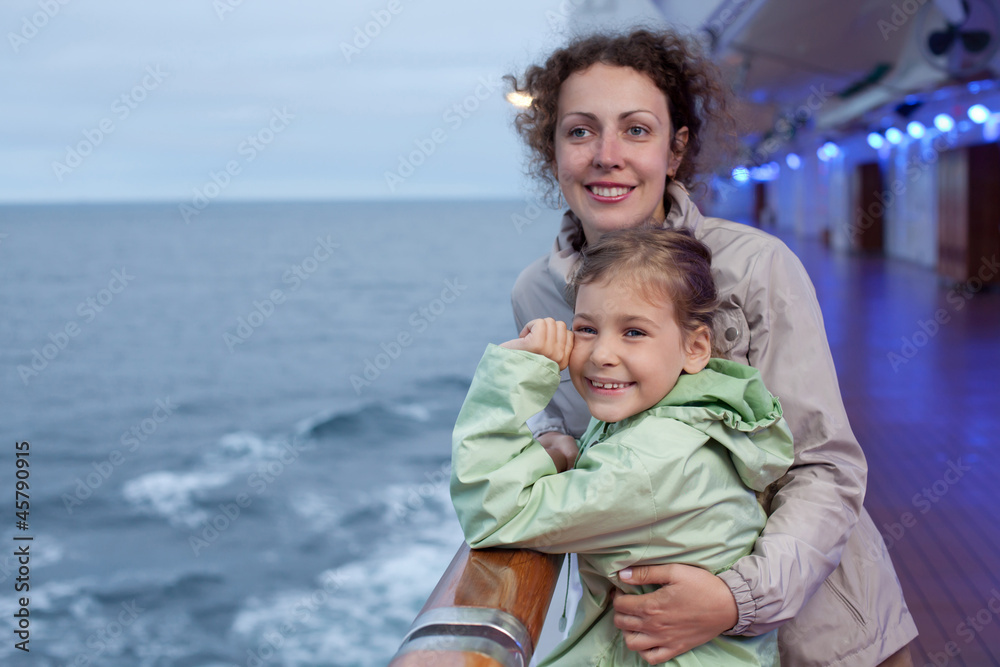 Smiling mother daughter posing on board passenger ship