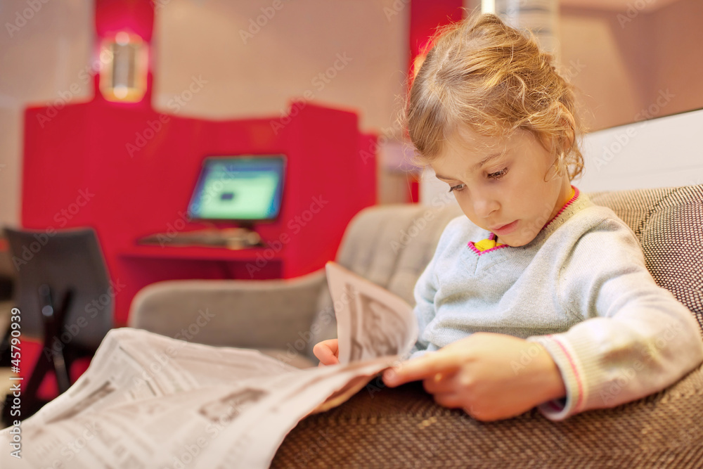 Little girl sitting in chair in cabin ship read newspaper Little girl sitting in chair in cabin ship read newspaper