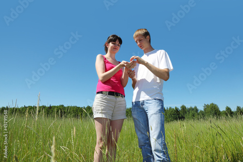 husband, wife look on berry in wife hands near forest photo