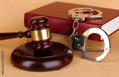 Gavel, handcuffs and.book on law on beige background