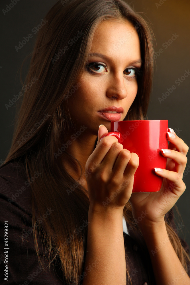 beautiful young woman with cup of coffee, on brown background beautiful young woman with cup of coffee, on brown background