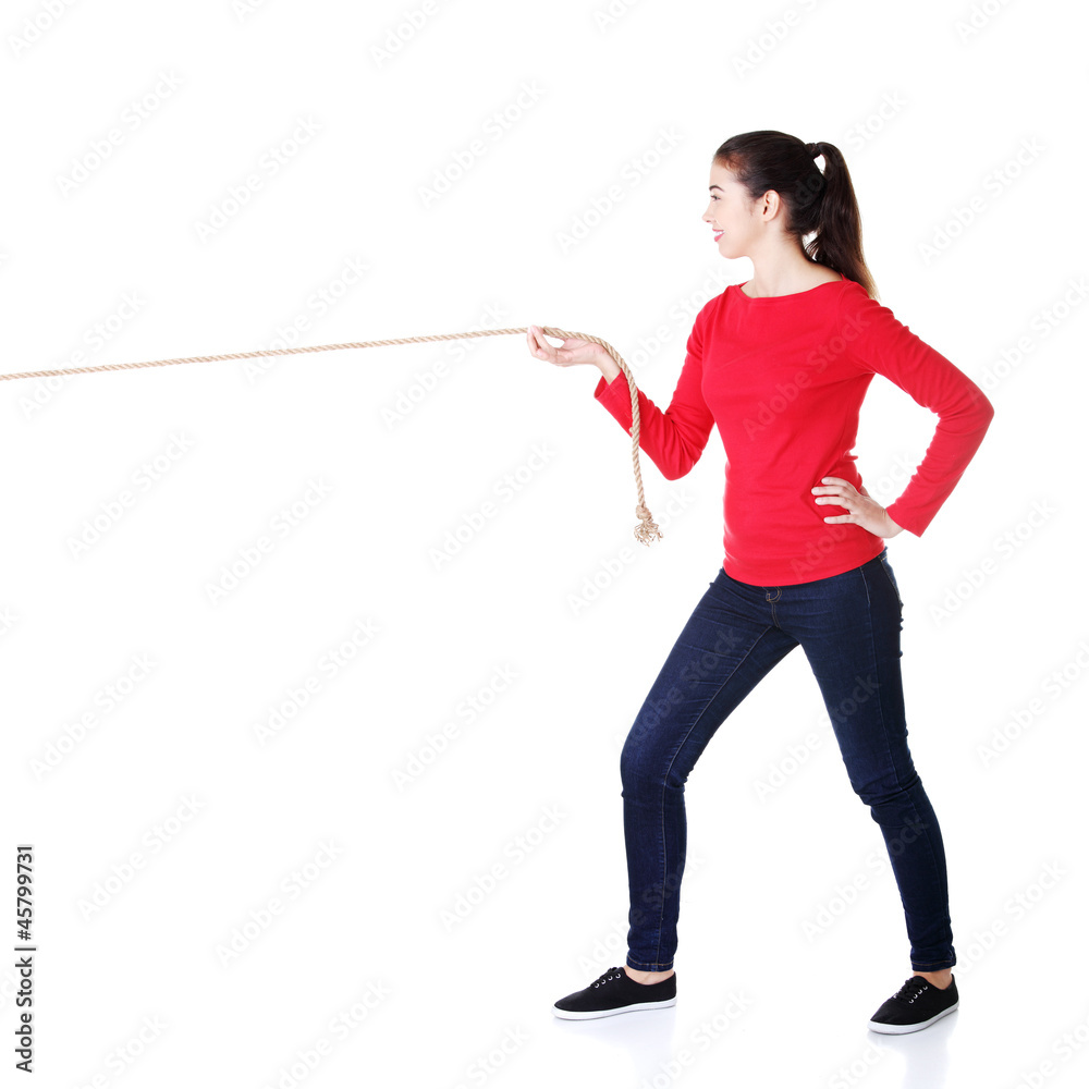 Happy casual woman pulling a rope with ease Stock Photo