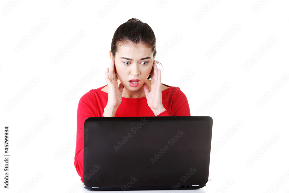 Surprised and disgusted woman working on laptop Surprised and disgusted woman working on laptop