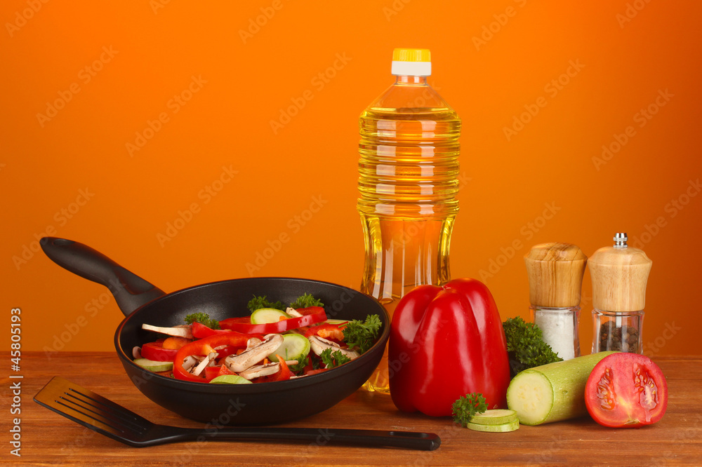frying pan with vegetables on red background frying pan with vegetables on red background