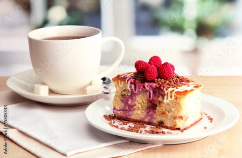 sweet cake with cup of tea on wooden table