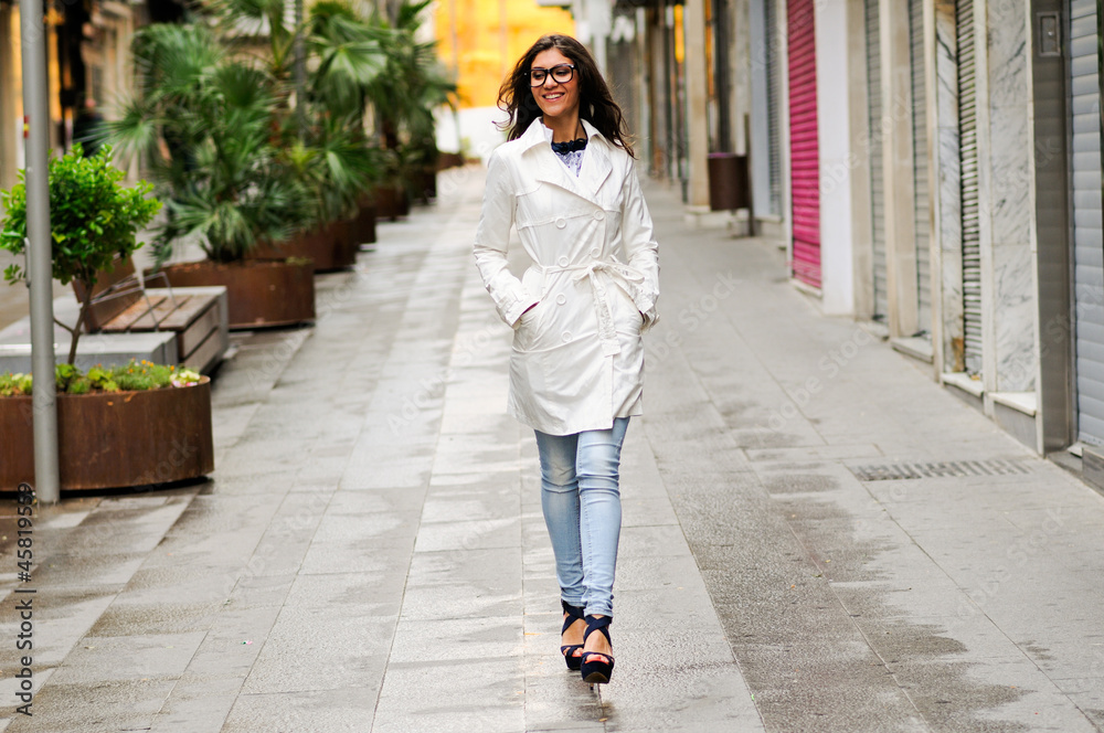 Beautiful woman with eyesglasses walking in urban background