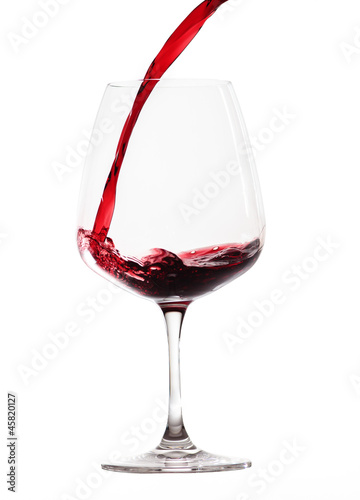 Rotwein wird in ein Rotweinglas gegossen (freigestellt)