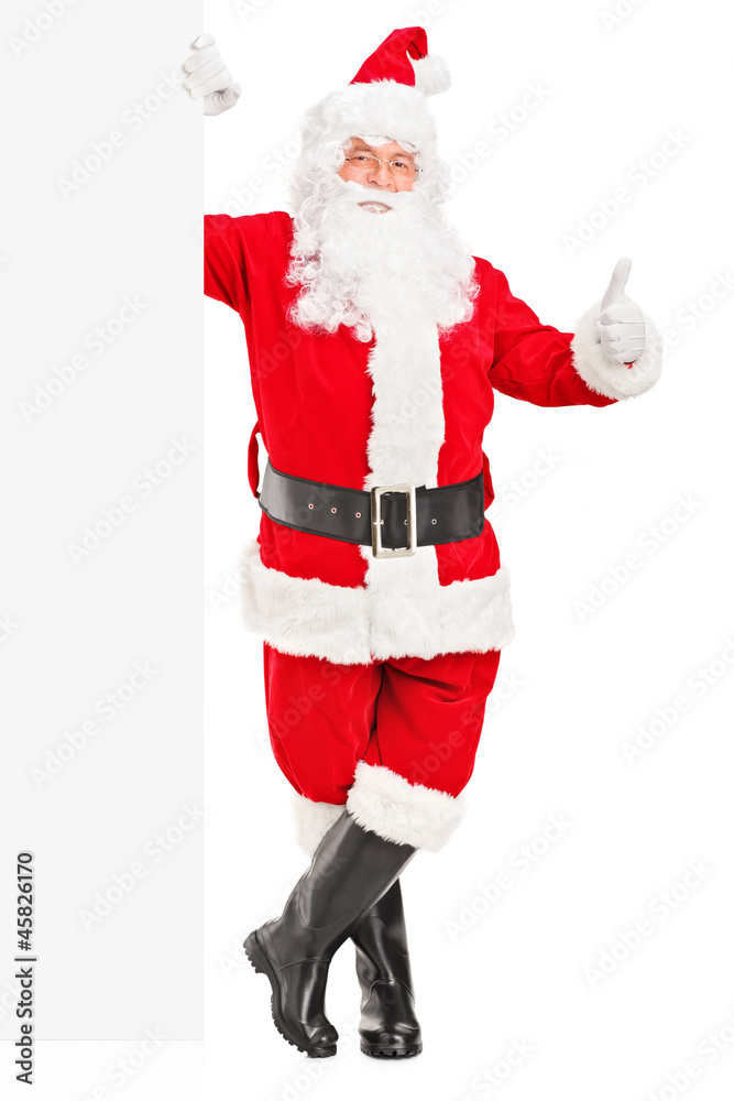 Happy Santa claus standing next to a billboard and giving a thum Happy Santa claus standing next to a billboard and giving a thum