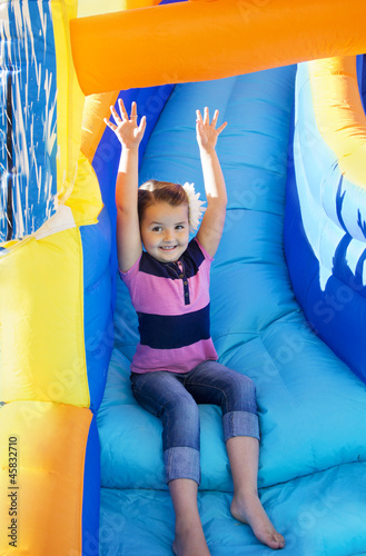 Fotografija Little Girl sliding down an inflatable Slide