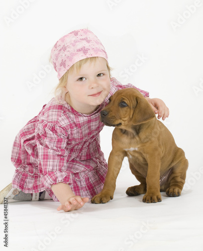 cute little girl hugging a rhodesian ridgeback puppy photo