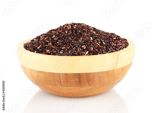 black rice in a brown wooden plat, isolated on white