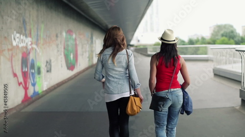 Female friends walking in the city, steadicam shot photo