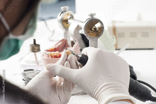 Dental technician working with articulator