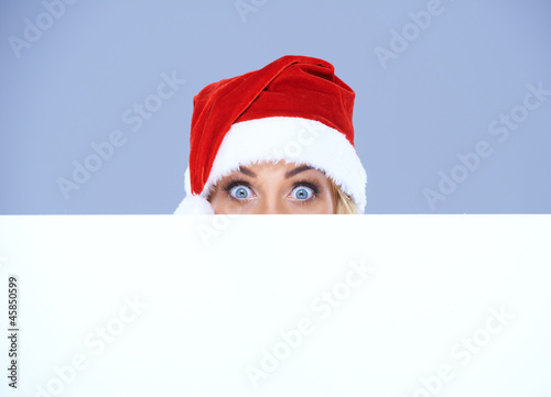 Woman head and eyes with Santa hat above white board © Dash