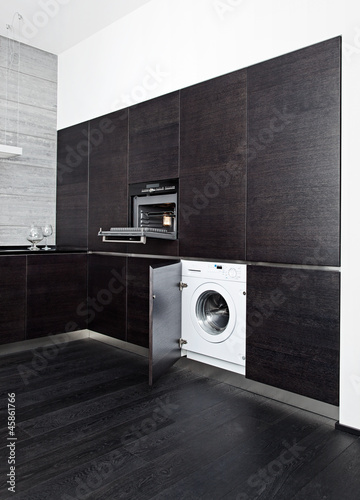 Build-in washing machine and cooker on modern black kitchen