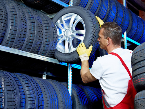 Car mechanic stores winter tires for tire changing photo