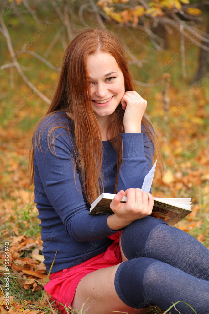Young beautiful girl with red hair reading a book Young beautiful girl with red hair reading a book
