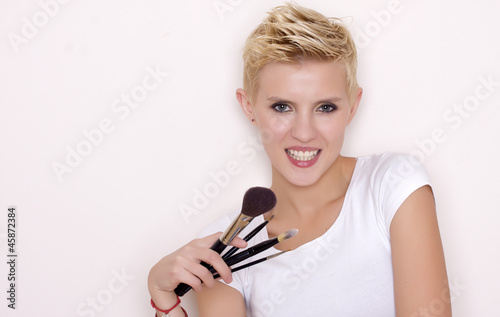 Make-up artist holding brushes