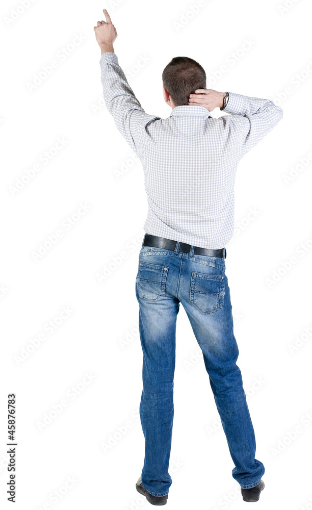 Back view of young man pointing at wall. Back view of young man pointing at wall.