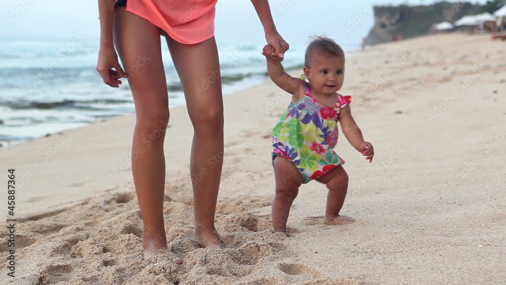 Beautiful mother with baby walking on beach Beautiful mother with baby walking on beach