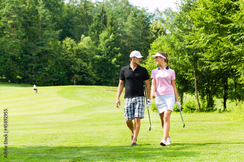 Junges sportliches Paar beim Golfen am Golfplatz