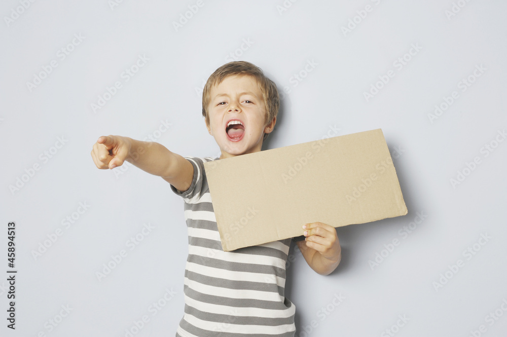 Zorniger Junge hält Schild mit Textfreiraum Zorniger Junge hält Schild mit Textfreiraum