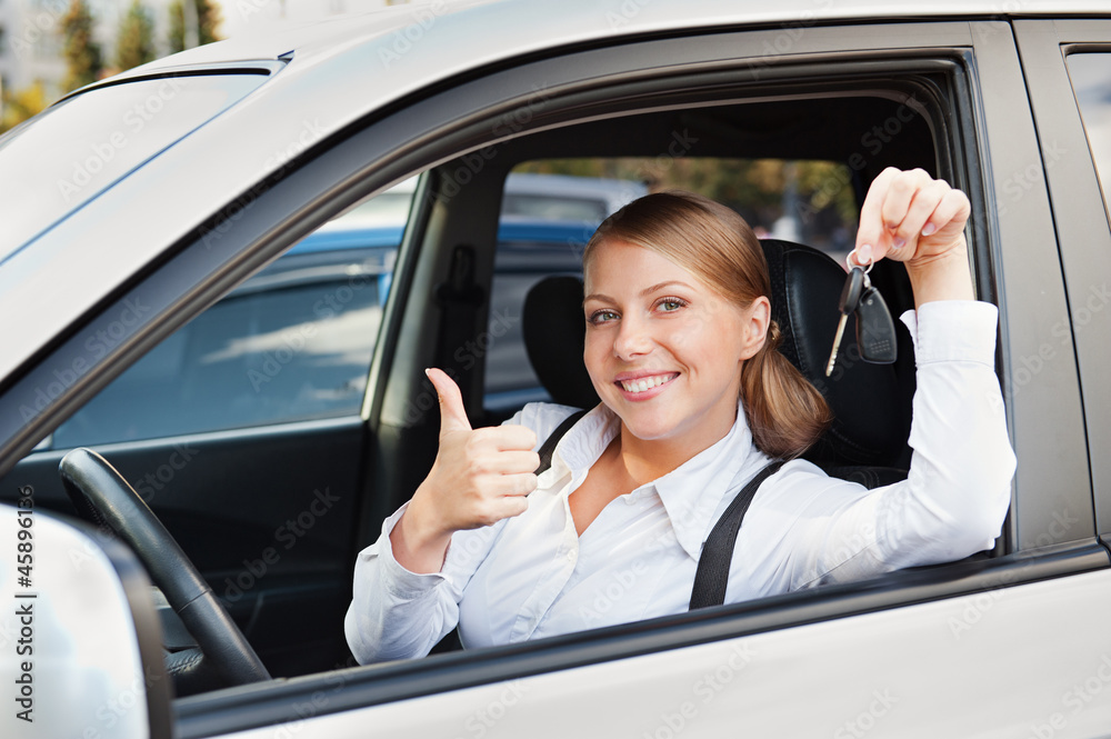 woman holding car key and showing thumbs up woman holding car key and showing thumbs up
