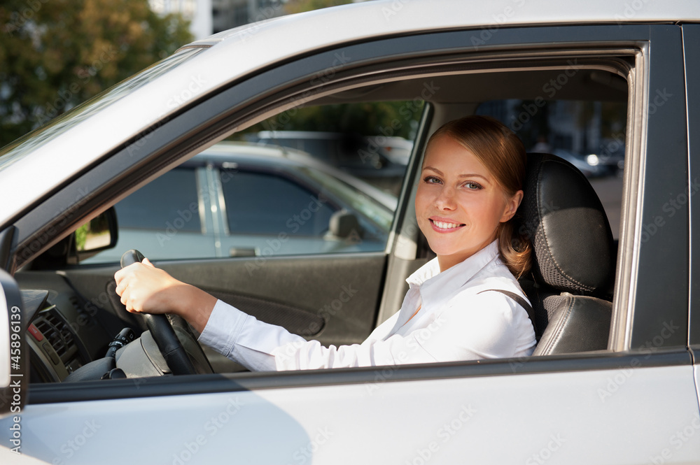 female at the wheel of her car