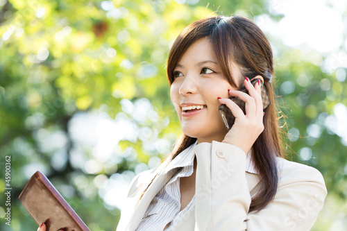 Beautiful businesswoman using a celluler phone. Portrait of asia photo