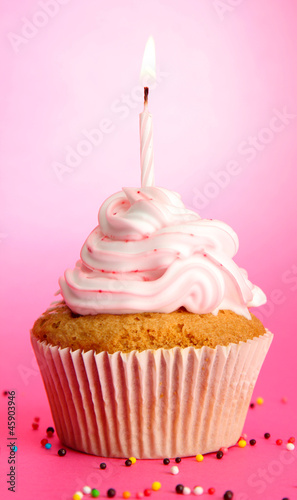 tasty birthday cupcake with candle  on pink background