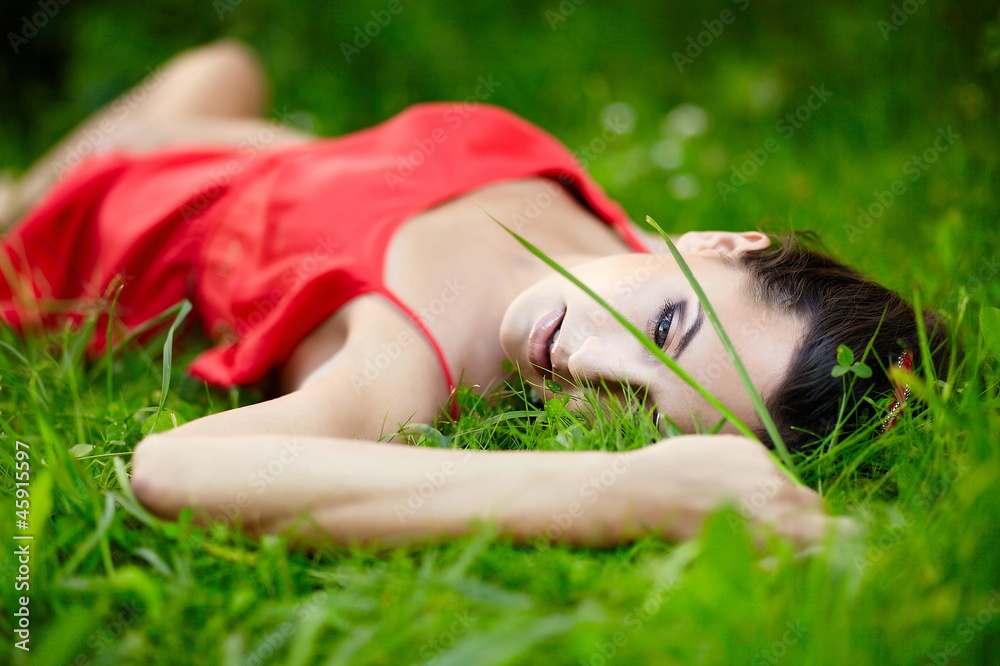 beautiful brunette girl lying in green summer bright grass beautiful brunette girl lying in green summer bright grass